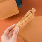 Beige påsklämma öppnad runt en påskant. Leverantörens produktfoto.